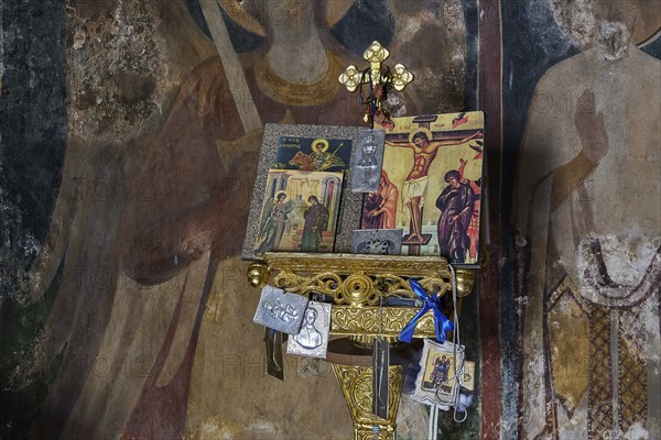 Icons above an ornamented altar in a church, surrounded by other religious symbols and wall