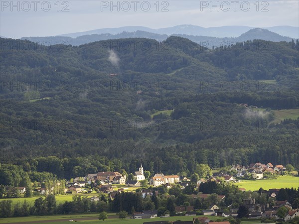 Evening light falls on the village of Heimschuh, hilly forest landscape, near Leibnitz, Styria,