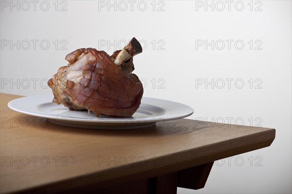 Grilled knuckle of pork on a wooden table