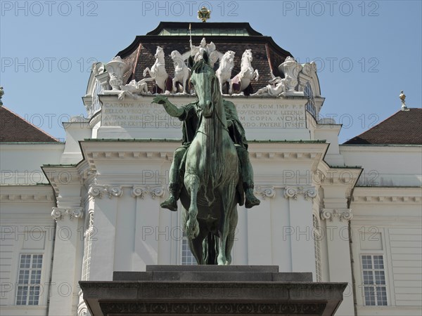 Equestrian statue in front of a magnificent baroque building with decorative elements, Vienna,