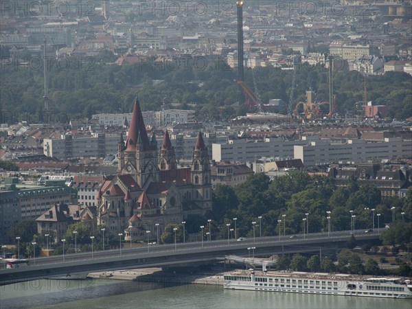 Historic church with striking towers in the middle of a dense urban landscape and a bridge over the