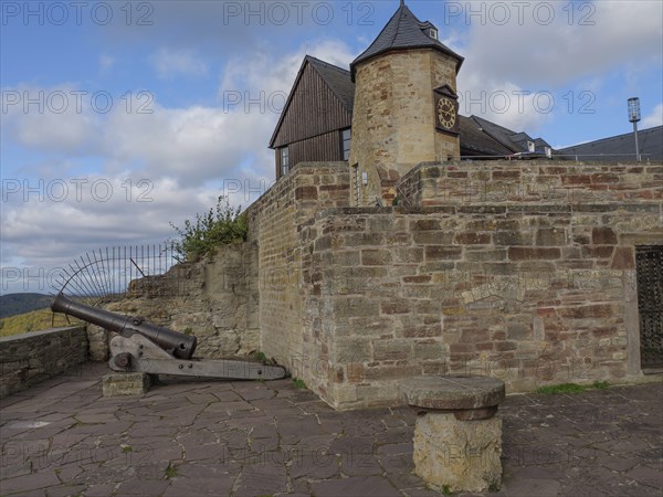 Historic castle with stone walls, a tower and a cannon under a partly cloudy sky, Waldeck, Hesse,