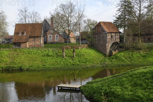 Idyllic landscape with traditional farmhouses and green lawns by a stream, Vreden, North