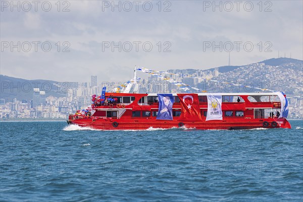 Supporters of the ruling AK party waving turkish flags on a red boat before presidential elections