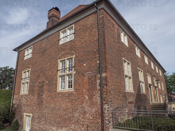 Large, two-storey brick building with many windows and a chimney under a cloudy sky, ramsdorf,
