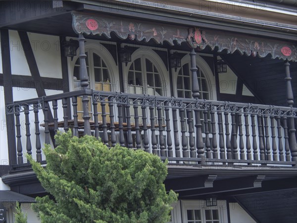 Close-up of a half-timbered house with detailed wooden railings on the balcony and black