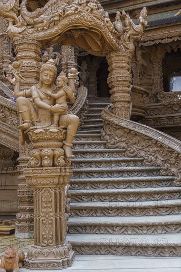 Close-up of an ornate wooden staircase inside the temple, with sculptures and carvings, Pattaya,