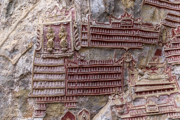 Hundreds of tiny Buddha Statues on limestone rock