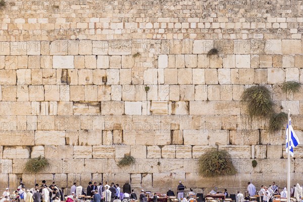 The Western wall in Jerusalem with state flag of Israel