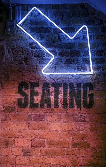 Seating sign with arrow pointing down
