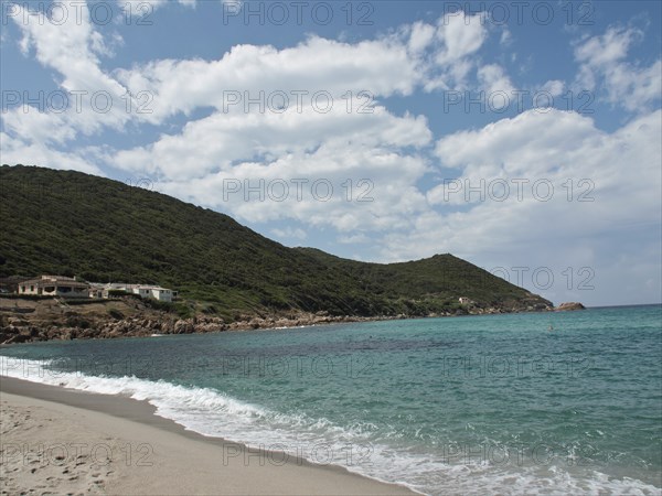 A wide sandy beach with gentle waves, surrounding hills and a loose woollen sky, ajaccio, corsica,