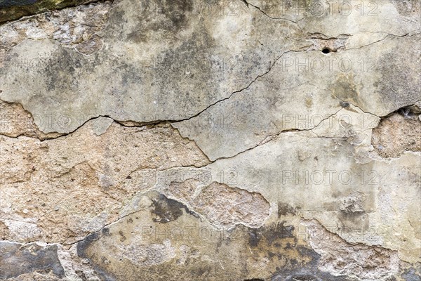 Grunge wall with fissures and plaster peeling of
