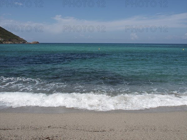 Waves crashing on a sandy beach, with a sweeping view of the open sea and the horizon, ajaccio,