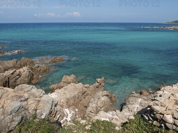 Rocky coastline with clear turquoise water and lush nature, ajaccio, corsica, france