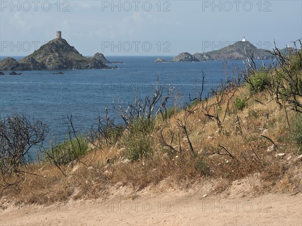 View of two islands in the sea, surrounded by barren hills and withered vegetation in the