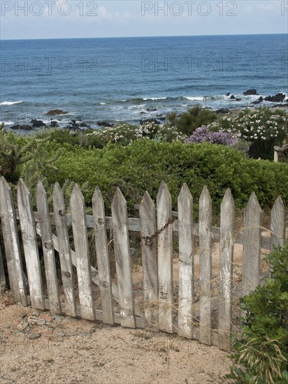 Old wooden gate with a view of the coastal landscape and the sea, ajaccio, corsica, france