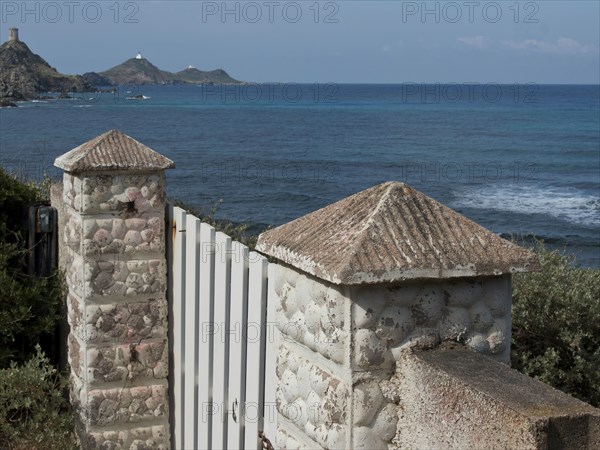 White Tor tor with stone columns overlooking the sea with hills in the background, ajaccio,