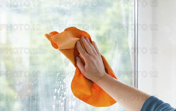 Employee cleaning window pane, wipe with a cloth, dry the water and soap, swab dusty and dirty