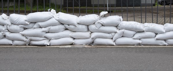 Sandbags for flood defense, river Moselle Trier in Rhineland Palatinate, flooded trees and paths,