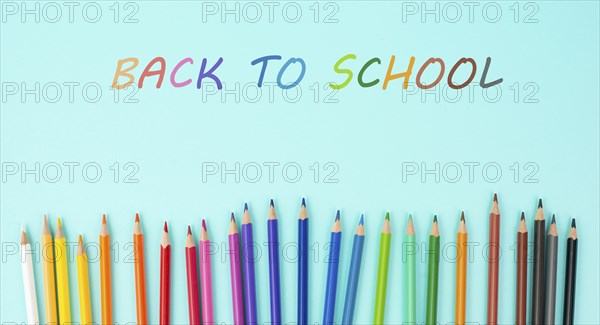 Color pencils collection in a row, back to school, drawing supplies, blue background with copy