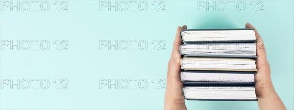 Hands holding pile of books, reading and learning new skill, knowledge is power, education concept,