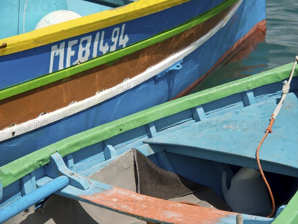 Close-up of several colourful boats lying in the water of a harbour, marsaxlokk, mediterranean sea,