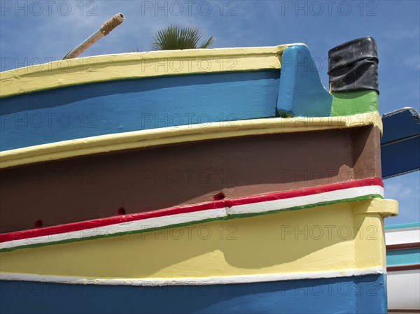 Multicoloured boat from the side with blue sky in the background, marsaxlokk, mediterranean sea,