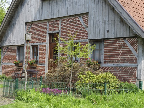 Traditional brick house with wooden elements, flower boxes and well-kept garden, marbeck,