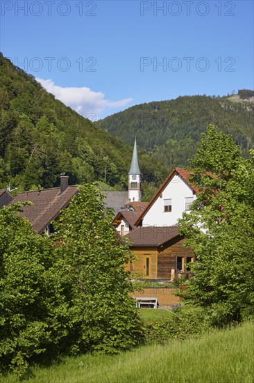Black Forest landscape with hills, houses and the church of St Wendelin in the district of