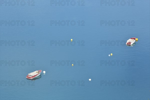 Two boats and buoys in the reservoir Lac de Sainte-Croix in the turquoise water near