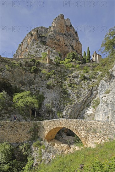 Stone arch bridge over the Ravin de Notre Dame stream and Notre-Dame de Beauvoir church, rock,