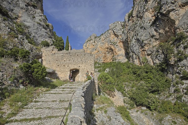 Path to Notre-Dame de Beauvoir church, archway, stone wall, rocks, mountains,