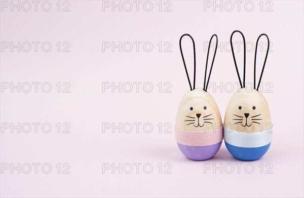 Easter bunny or rabbit couple cuddle together, wooden egg, spring holiday greeting card