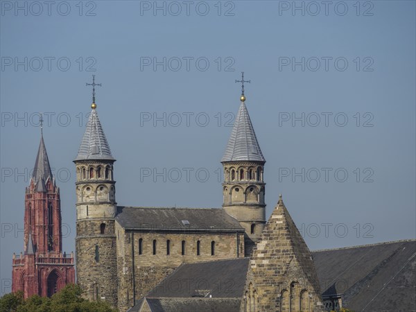 Two historic towers and buildings, shining in the calm daylight, Maastricht, limburg, the