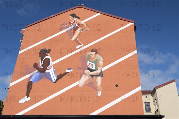 Runner on tartan track, painted house wall, Änggarden neighbourhood, Majorna-Linné district,