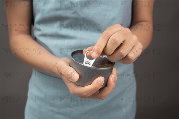 Opening a tin can with preserved food, box with tuna fish, processed ingredients, feeding a pet