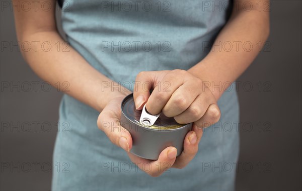 Opening a tin can with preserved food, box with tuna fish, processed ingredients, feeding a pet