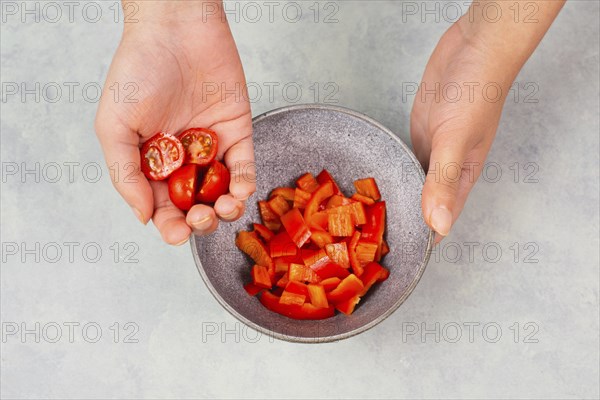 Tomatoes and red sliced pepper pieces in a bowl, prepare healthy food with paprika vegetables,
