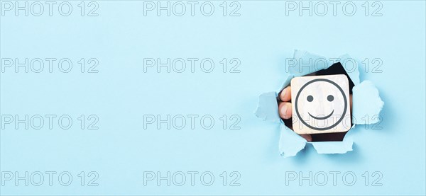 Holding a head with a smiling face in the hands, mental health concept, positive mindset, support