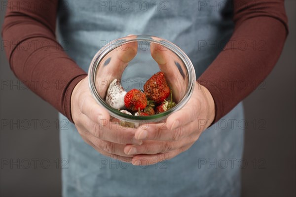 Moldy strawberry fruits with spot fungus in a jar, rotten strawberries, decomposition of the food