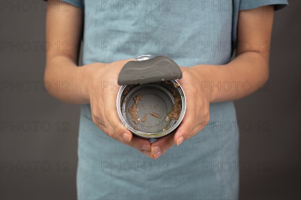 Open tin can with preserved food, empty box of tuna fish, processed ingredients, feeding a pet