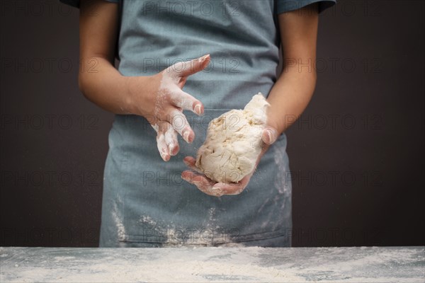 Baker kneading dough for pizza or artisan bread with his hands, prepare ingredients for food,