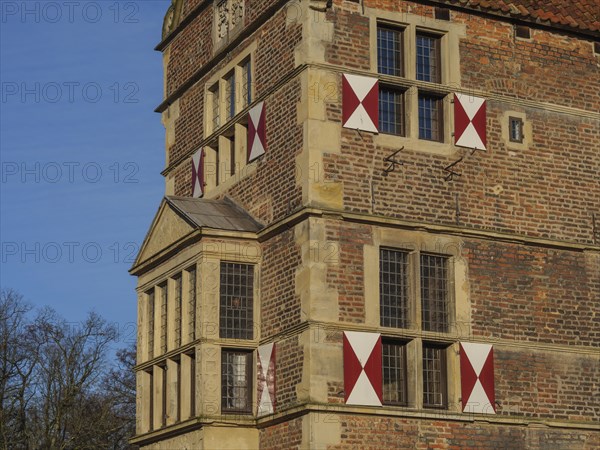 Detail of a historic castle with red and white shutters and a small tower, lüdinghausen,