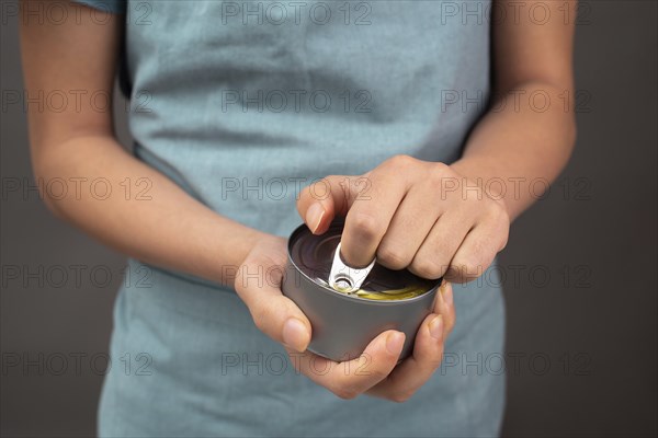 Opening a tin can with preserved food, box with tuna fish, processed ingredients, feeding a pet