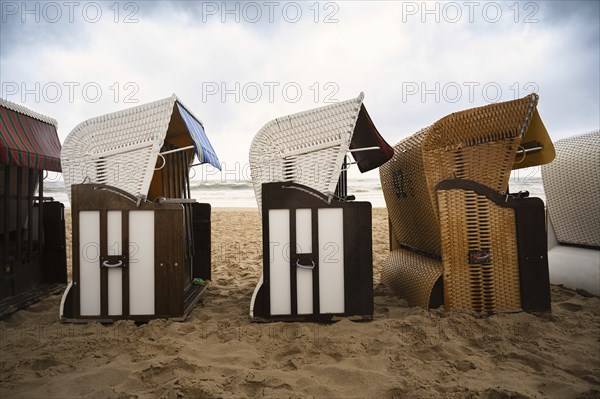 Roofed wicker beach chairs at the baltic sea beach, coast at the island of Usedom in Germany, storm