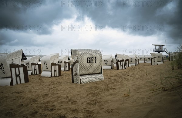 Roofed wicker beach chairs at the baltic sea beach, coast at the island of Usedom in Germany, storm