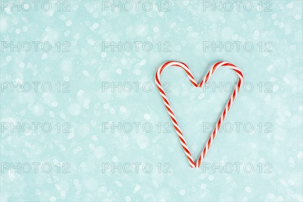 Candy cane forms heart shape, Christmas holiday background, winter season greeting card