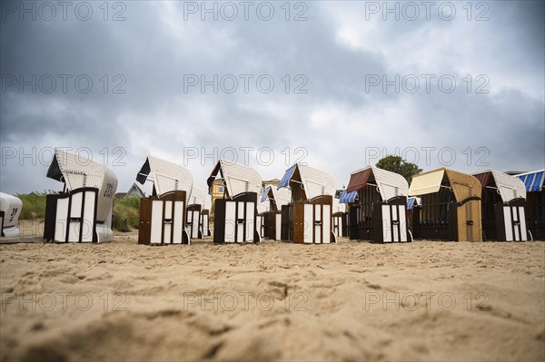 Roofed wicker beach chairs at the baltic sea beach, coast at the island of Usedom in Germany, storm