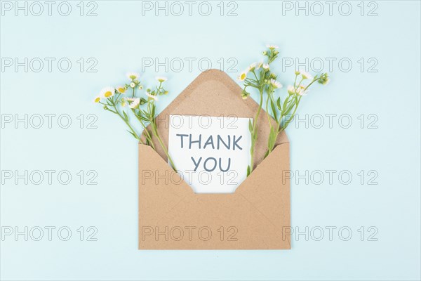 Thank you card in an envelope surrounded by flowers, being thankful, support, help and charity