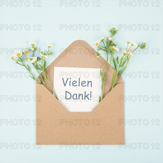 Thank you card in an envelope surrounded by flowers, being thankful, support, help and charity